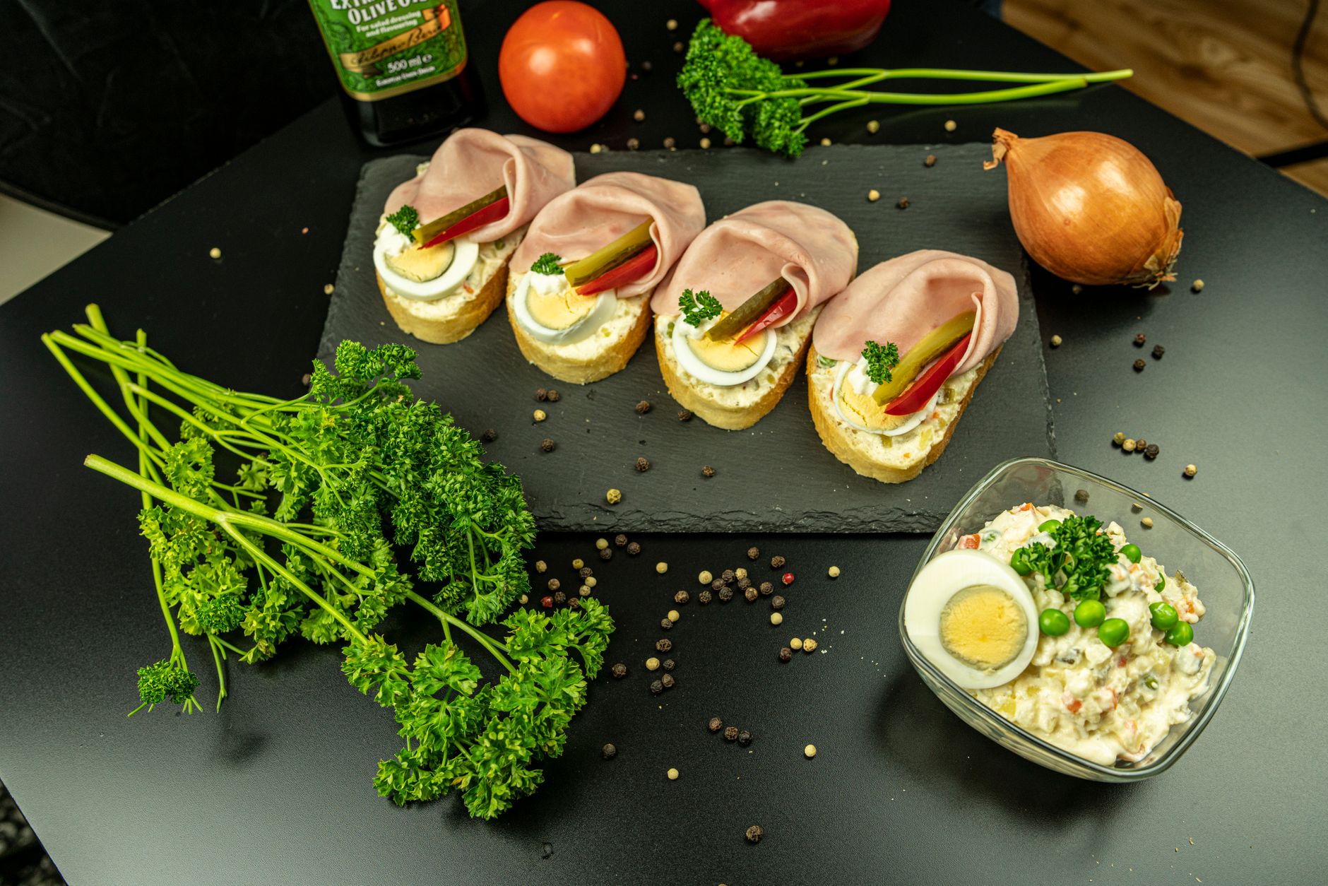 Sliced bread topped with ham and egg on a black plate