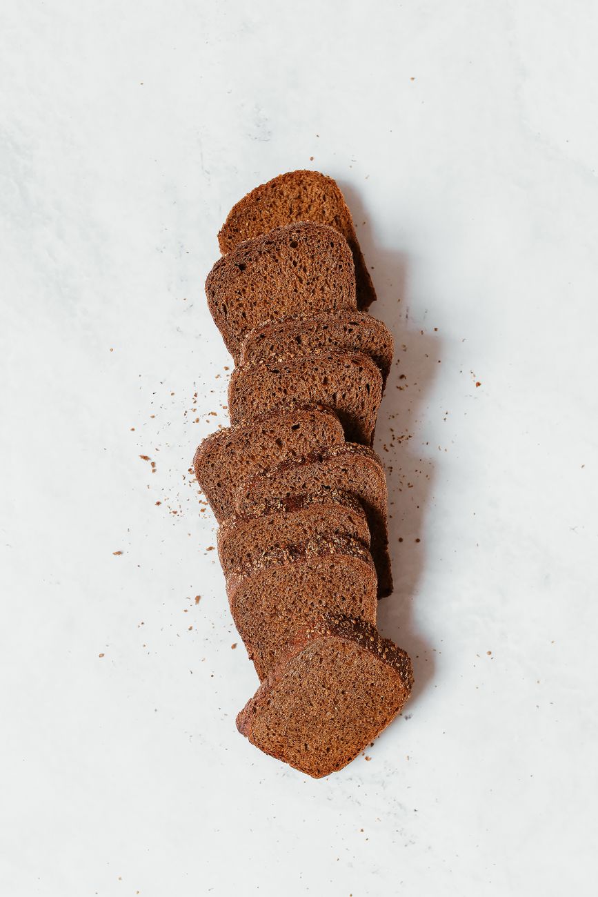 Freshly sliced rye bread on a white surface, showcasing texture and color