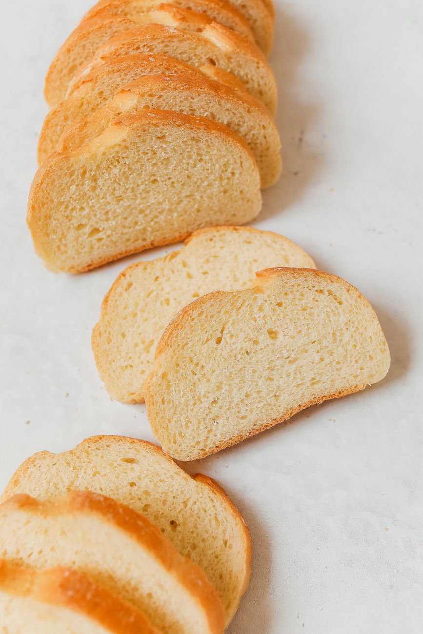 A close-up view of freshly sliced white bread arranged neatly on a marble surface