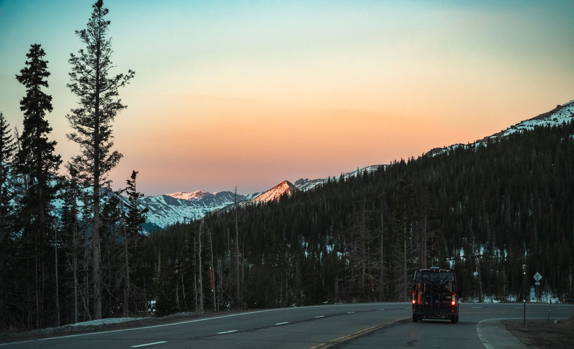Snow-covered Colorado mountain peaks lit by sunset light