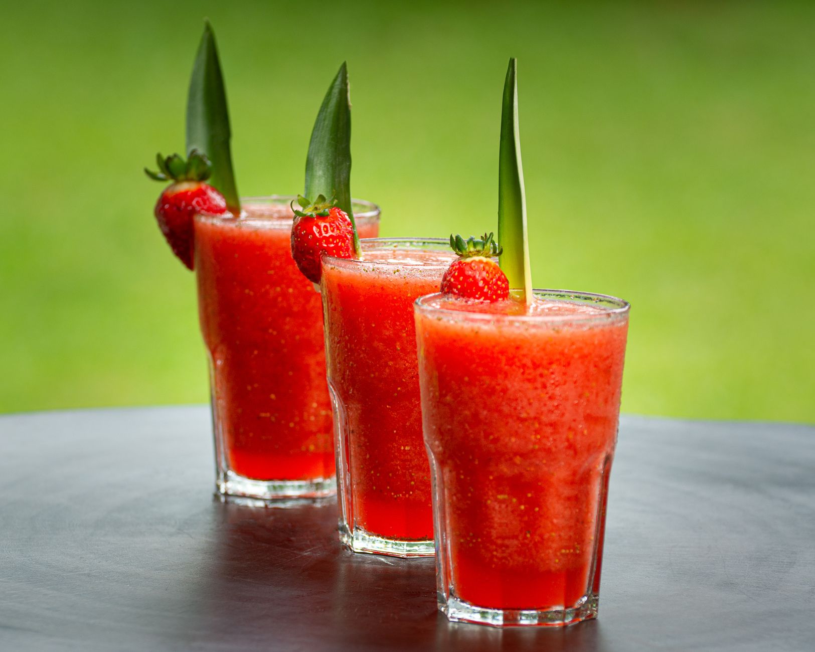 Vibrant strawberry smoothies garnished with pineapple leaves