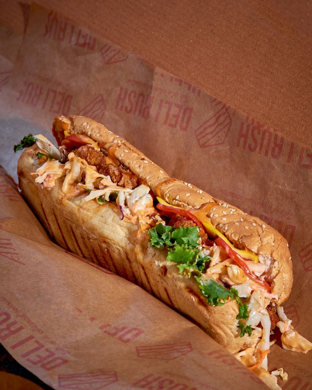 Close-up of a fresh sub sandwich with lettuce, tomatoes, and chicken
