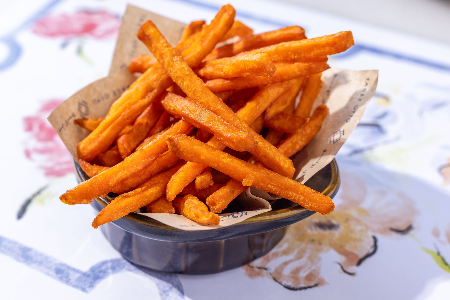 A plate of delicious sweet potato fries on an artistic table