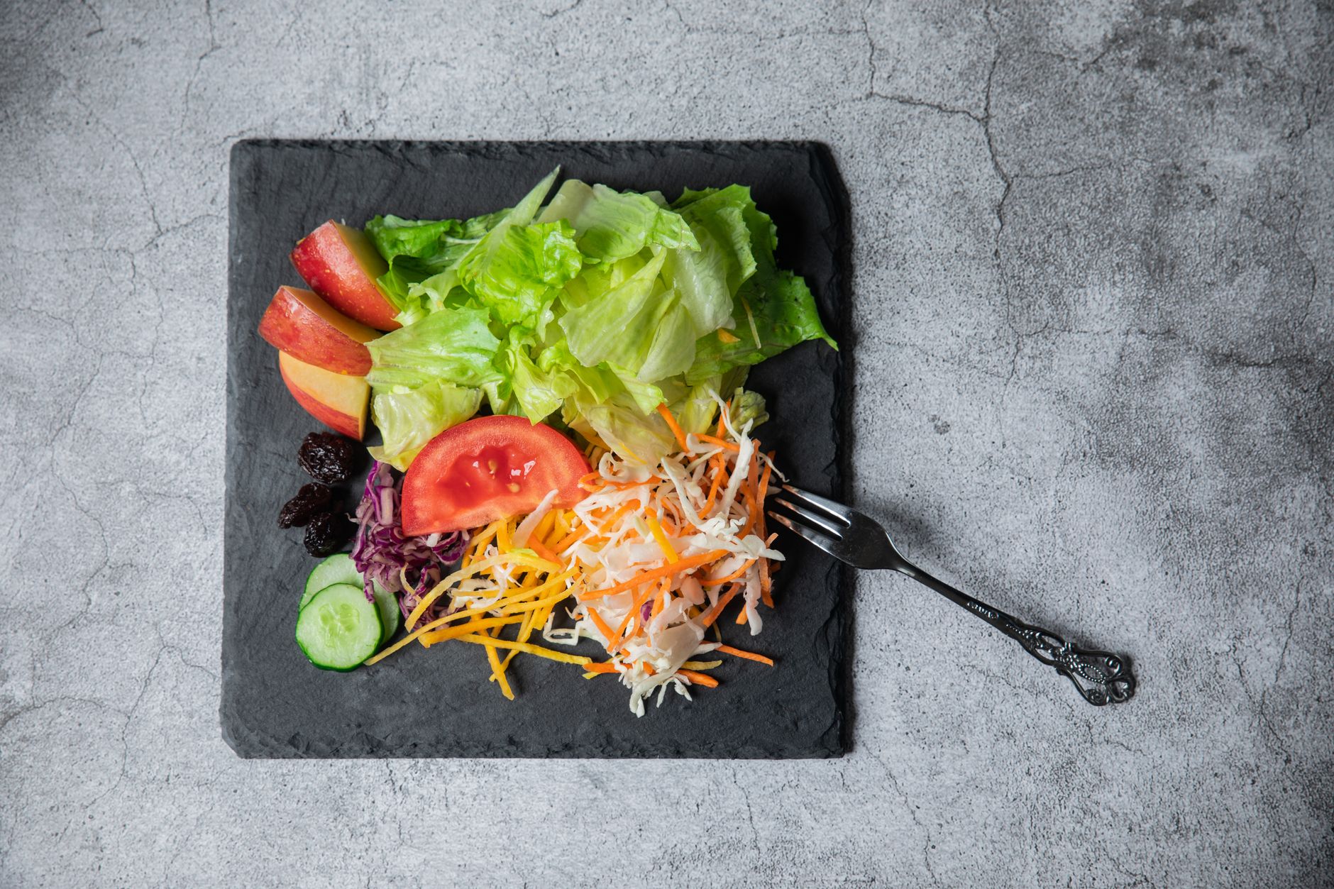 Top view of a colorful vegetable and fruit salad with lettuce, tomato
