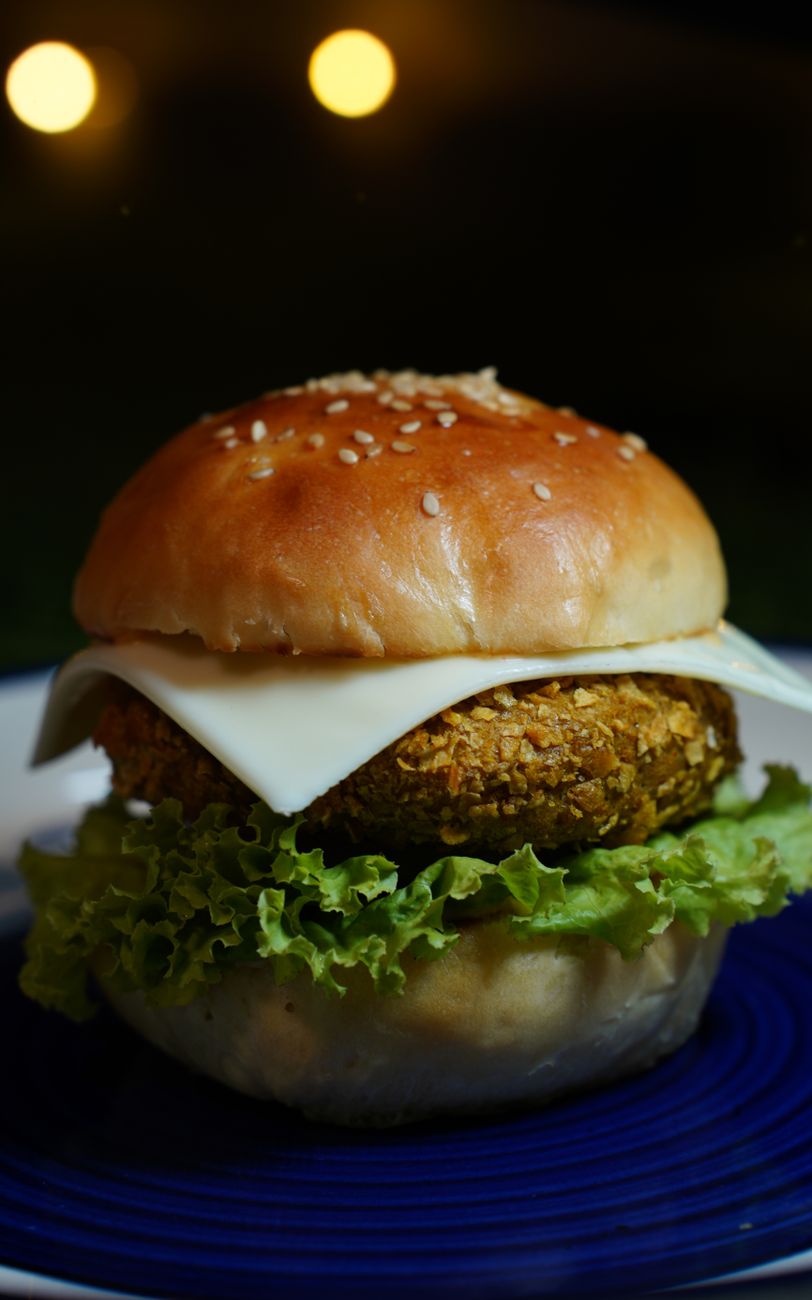 A close-up of a delicious veggie burger with cheese and lettuce