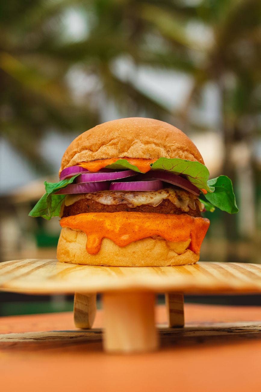 Close-up of a delicious veggie burger with fresh vegetables and creamy sauce