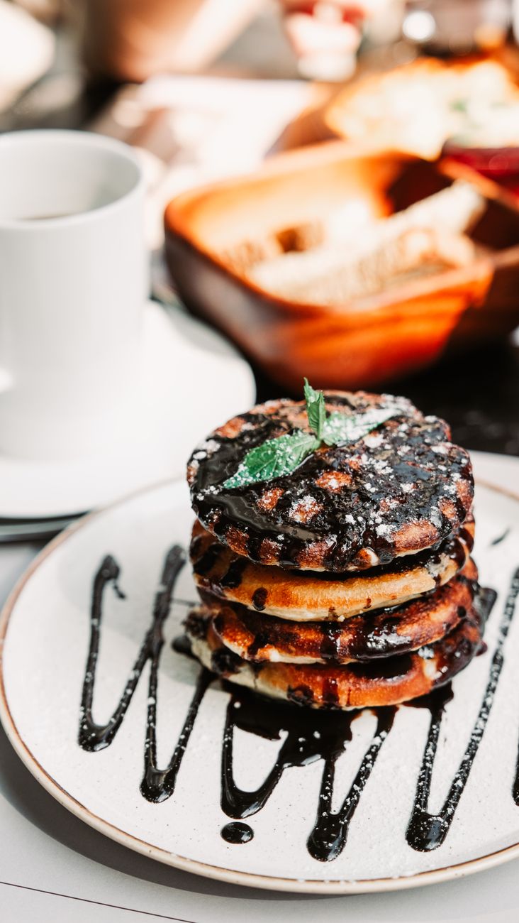 A plate of waffles topped with chocolate syrup and powdered sugar