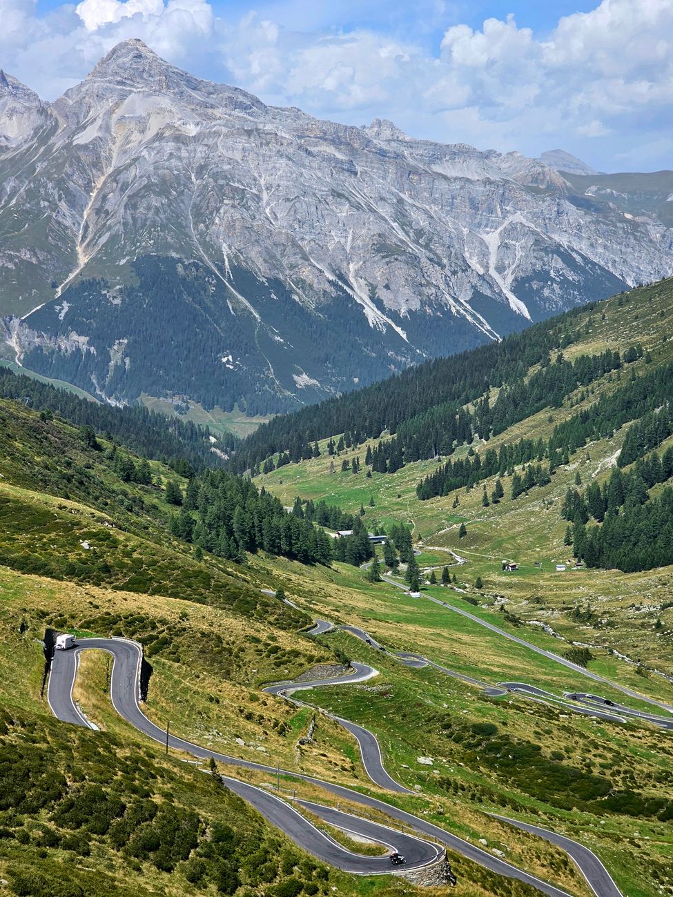 A breathtaking view of a winding mountain road amid lush greenery